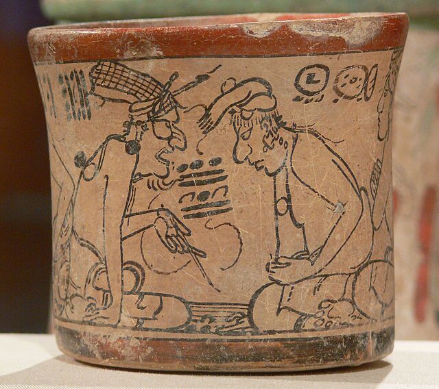 High priest (aj k'in), showing the eye of Kinich Ahau Itzamna, the creator god of the Maya, to a scribe. Kimball Art Museum, Fort Worth Texas.